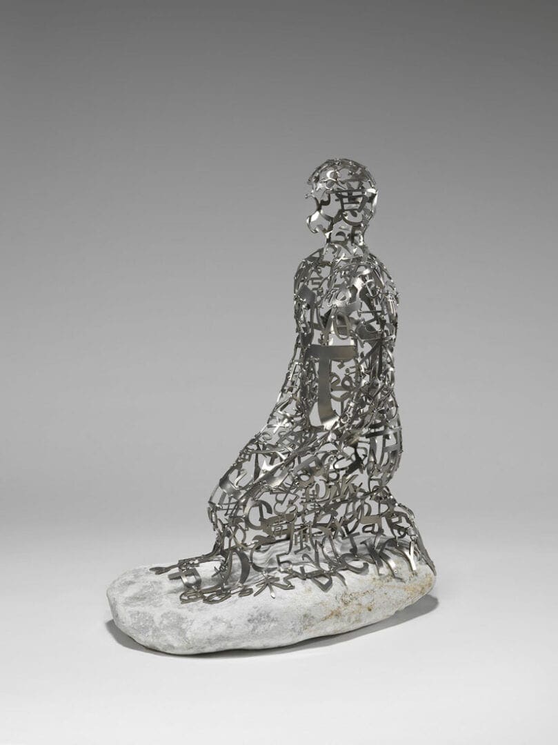 Metal letter sculpture of kneeling human